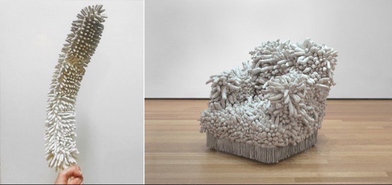 Two white, textured objects resembling coral or sea anemones: a long, thin one held by a hand, and a large armchair in a gallery.
