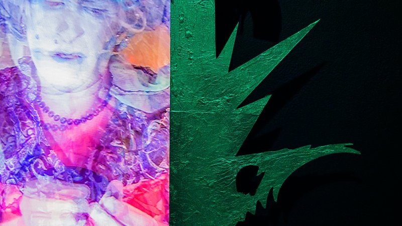 Divided composition: left side shows a digitally distorted portrait in pinks and purples; right side features a textured, metallic green, jagged shape against a black background.
